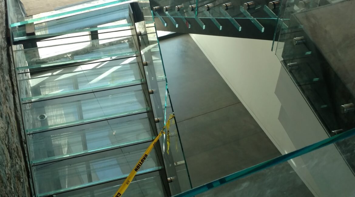 Glass Unlimited Glass railing with glass treads and glass flooring. This is an all Glass staircase.