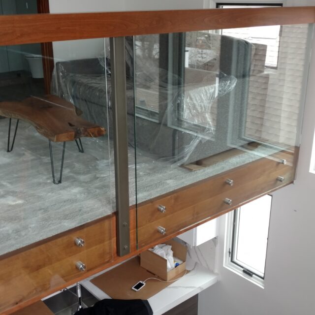 Glass Unlimited glass railing with wood cap rail and stand-offs.