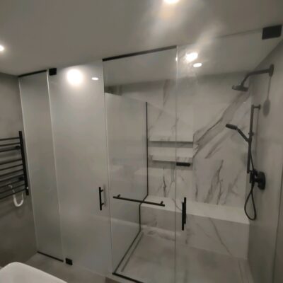 Custom Glass Enclosure for Shower and Toilet. Glass is privacy glass with a frosted finish. Custom Hardware with frameless glass.