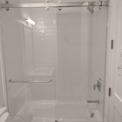 A Glass unlimited Frameless Glass Bath and Shower Sliding Door with polished steel hardware.